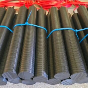 German text advertising resistant plastic grounding electrode; photo shows bundles of black ribbed grounding rods tied with blue ties laid in a row, likely for electrical grounding.