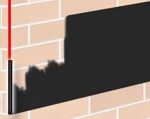 Brick wall with a large black rectangle obscuring part of the surface; a thin red vertical line on the left edge.
