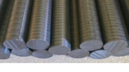 Schwarze, gerippte Elektrodenstangen liegen in Reihen, blau gebunden; Bildtext: Weltweit erste vollständig resistente Elkinet-Elektrode aus Hartplastik.